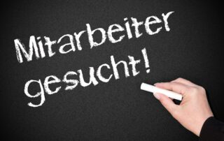 Eine Tafel mit der Aufschrift Mitarbeiter gesucht.